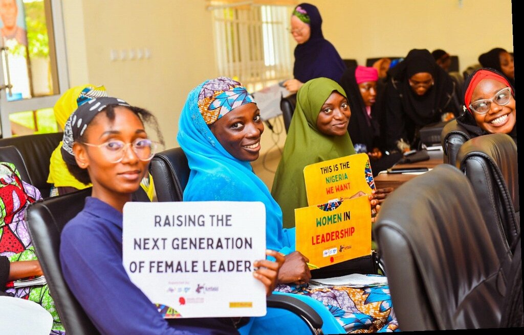 Young women with leadership signs
